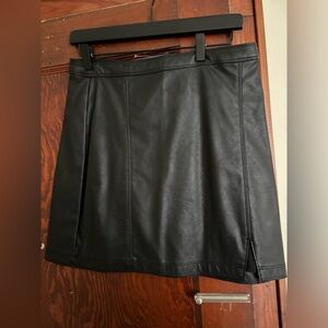Mini black leather skirt. With little slit.